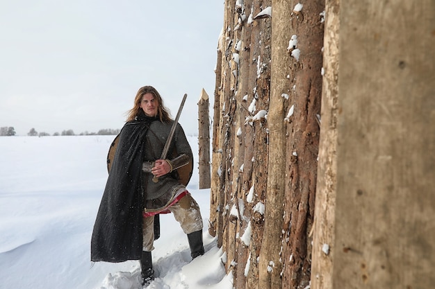 Defender the young warrior in mail armor armed with a sword and an ax