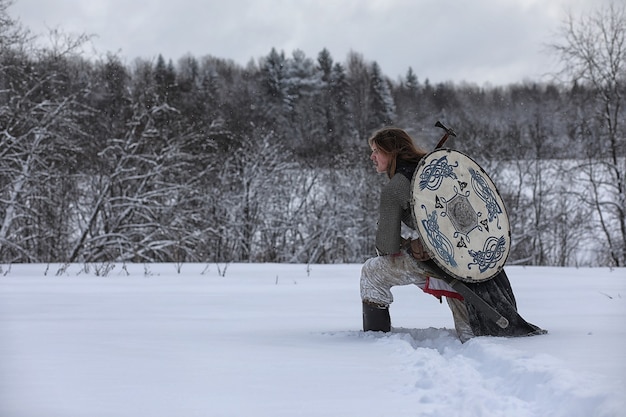 Defender the young warrior in mail armor armed with a sword and an ax