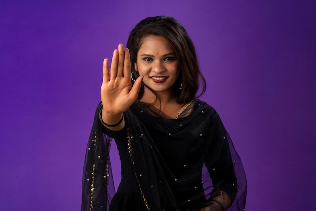 Definitely no prohibited access Portrait of a girl crossing hands and showing palm stop gesture warning of end finish forbidden way indoor studio shot on purple background