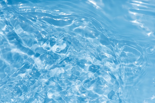写真 透明な青い色の透明な冷静な水面の質感にスプラッシュと泡があります