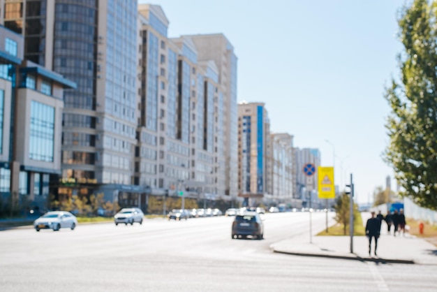 Defocus city street road with cars houses people at the crossing Urban abstract background