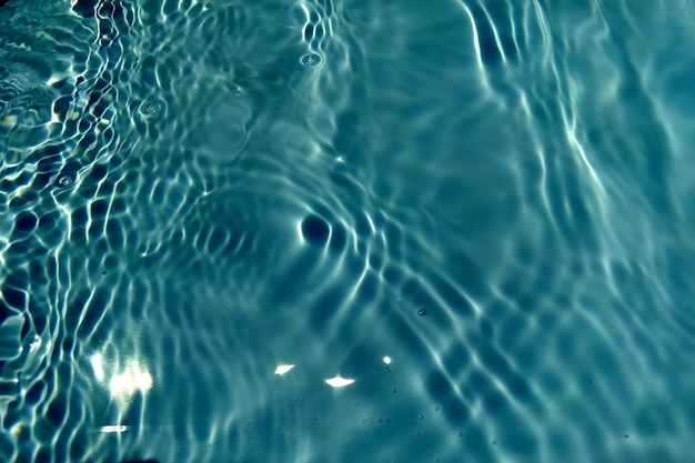 Defocus wazig transparant blauw gekleurd helder kalm wateroppervlak textuur met spatten en zeepbel Trendy abstracte natuur achtergrond Watergolf in zonlicht met kopieerruimte Blauwe aquarel schijnt
