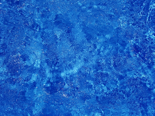 Defocus wazig transparant blauw gekleurd helder kalm wateroppervlak textuur met spatten en zeepbel Trendy abstracte natuur achtergrond Watergolf in zonlicht met kopieerruimte Blauwe aquarel textuur