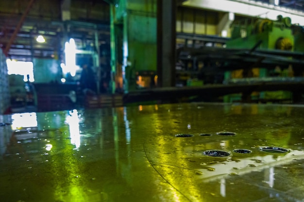 Defocused abstract old factory background and oily horizontal steel surface in foreground