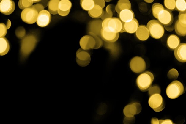 Bokeh sfocato natale grandi luci dorate nell'angolo in alto a destra su sfondo nero