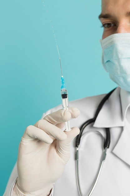 Photo defocused doctor holding up syringe with vaccine