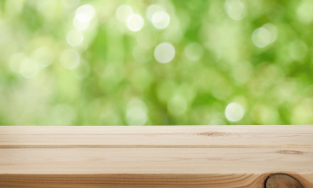 Defocused Green juicy background and empty wooden table in nature outdoor