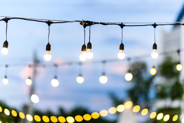 Defocused image of illuminated lights against sky