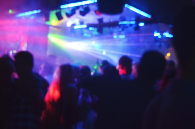 Defocused image of people at illuminated nightclub