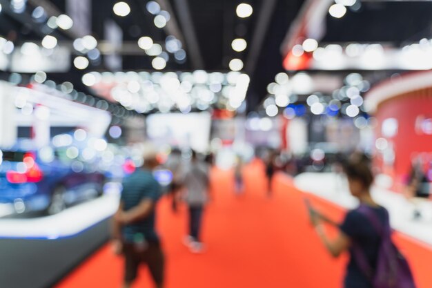 Photo defocused image of people walking in illuminated exhibition