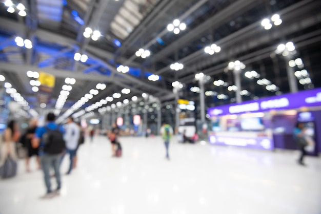 Foto immagine sfocata di persone che camminano su una stazione ferroviaria illuminata