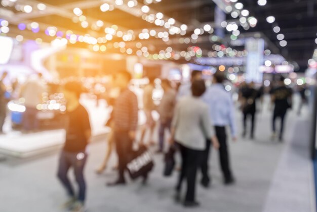 Defocused image of people walking on illuminated street in city