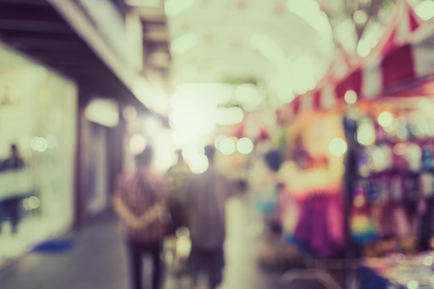 Photo defocused image of people walking on illuminated street at night