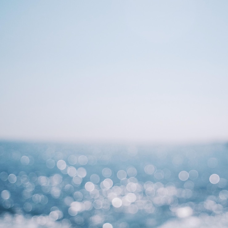 Photo 澄んだ空に照らされた海の画像