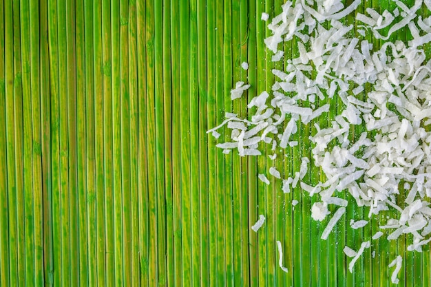 Dehydrated coconut flakes on a green background
