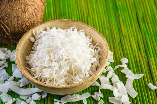 Dehydrated coconut flakes in wooden bowl.