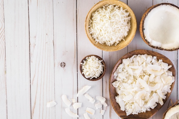 Dehydrated coconut flakes in wooden bowl.