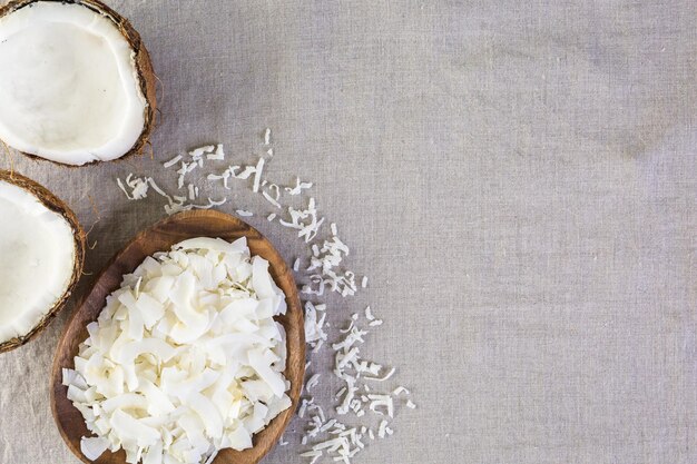 Dehydrated coconut flakes in wooden bowl.