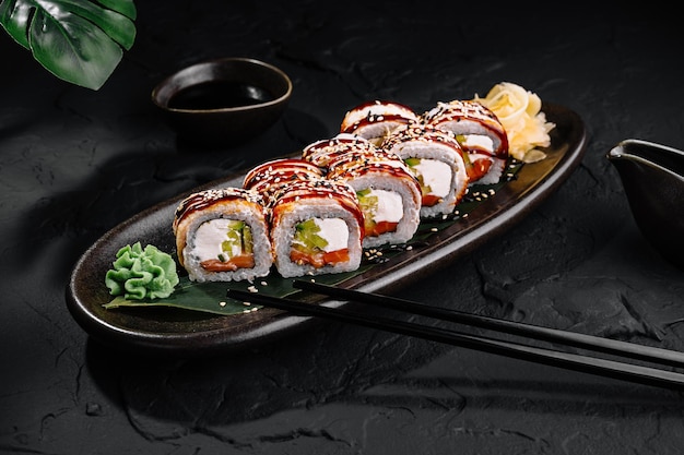 Foto un delizioso piatto di sushi su uno sfondo scuro.