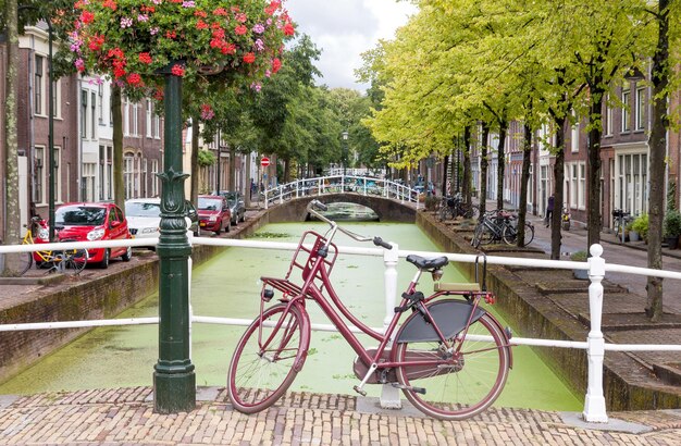 Foto vista della città di delft nei paesi bassi con canale d'acqua e bicicletta