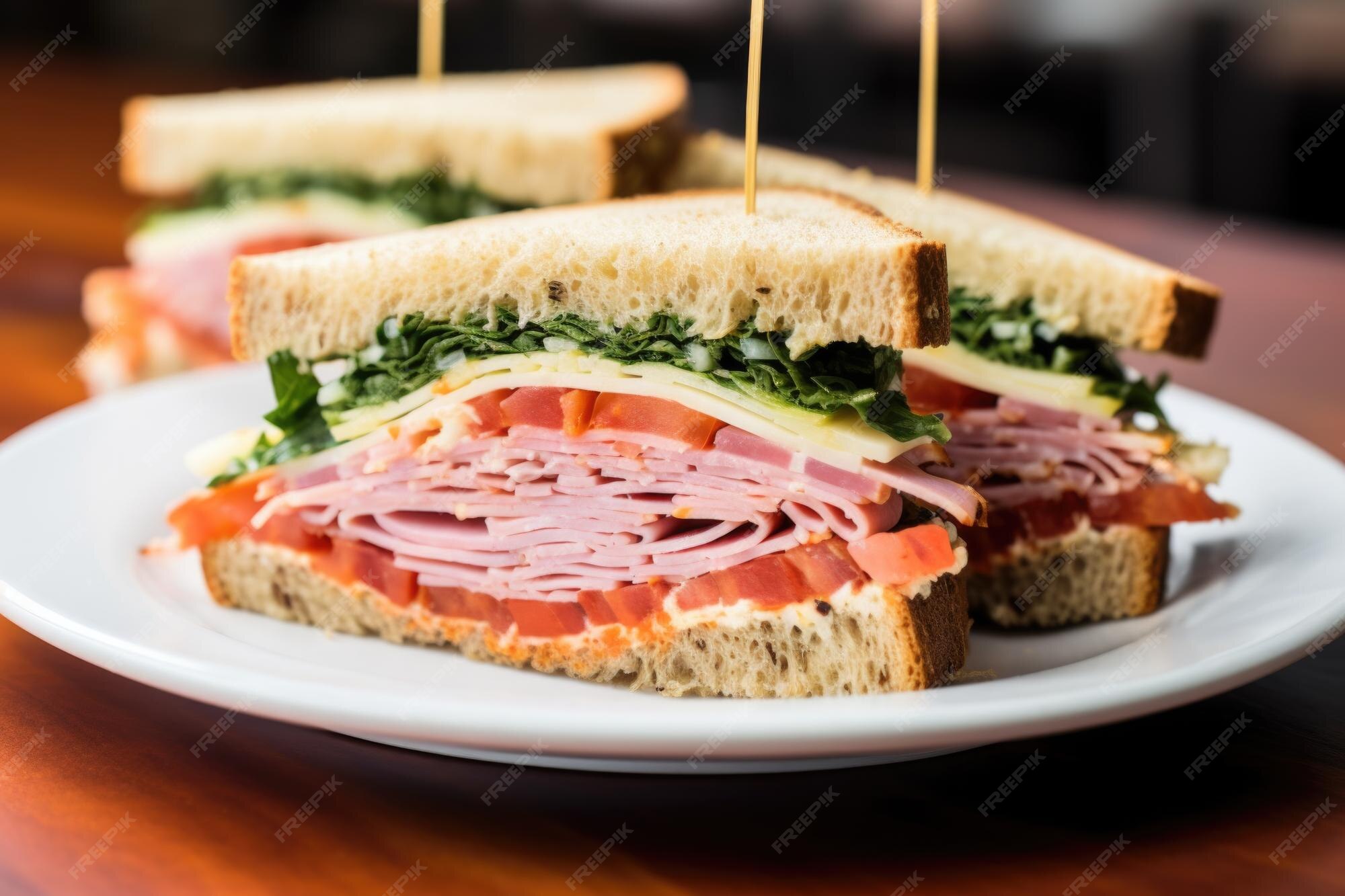 Premium AI Image Deli meat sandwich cut in half on a white plate