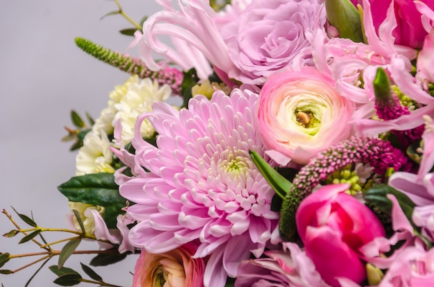 Delicaat vers boeket van verse bloemen met roze ranonkel, roos, astra en chrysant.