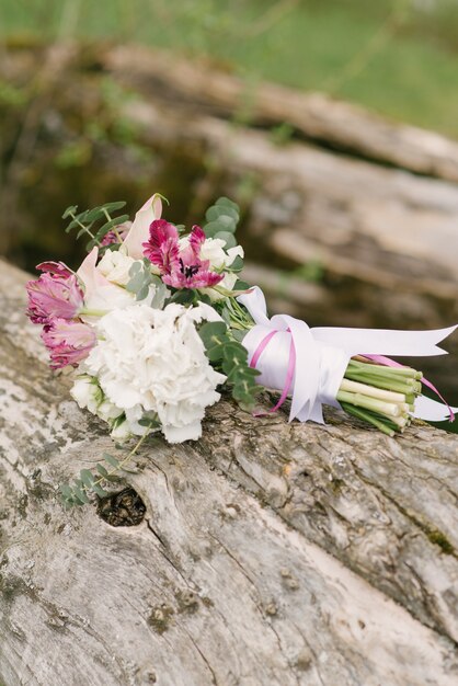 Delicaat wit roze bruidsboeket omgeven door de natuur