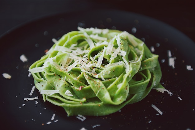 Delicacy green pasta with homemade spinach and broccoli under a parmesan cheese and sesame seeds