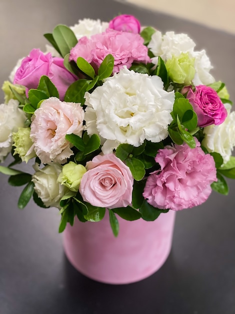Нежный букет цветов в коробке из белой и розовой эустомы, красивых роз и зелени.