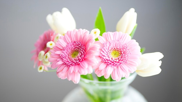 Delicate bouquet of pink and white flowers on a gray background Image with selective focus