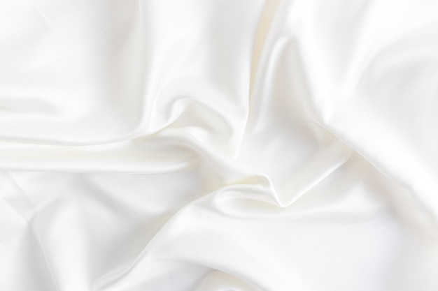 Delicate bruiloft achtergrond gemaakt van satijn stof met zachte golven in de kleur van champagne crème lay-out