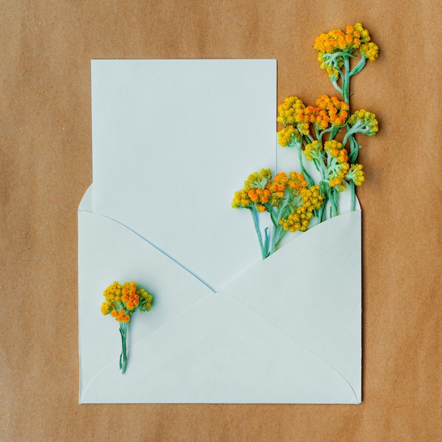 Delicate card with wild dry yellow flowers in an envelope with copy space for design.