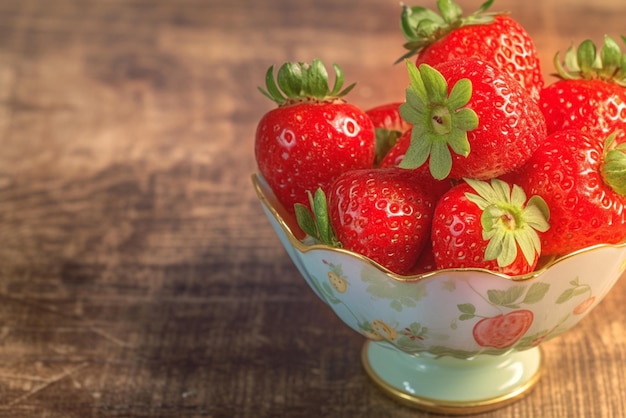 Delicate cup holds a bounty of fresh luscious strawberries