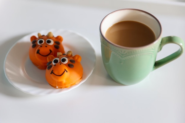 Delicate dessert in the form of funny animals with a cup of coffee on the table