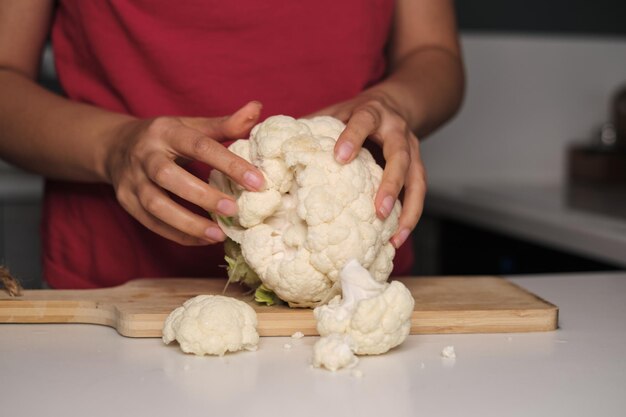 Photo delicate hands break apart colorful cauliflower on a modern kitchen countertop discover the joy of