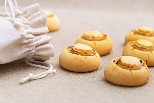 Delicate knapperige koekjes in de vorm van champignons. Gebakken zoete koekjes gemorst uit de zak op textieloppervlak. Kopie ruimte.