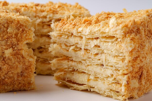 Delicate lagen puff pastry gevuld met room op een eenvoudige witte achtergrond