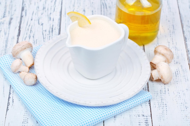 Delicate mushroom sauce in pitcher on wooden table closeup