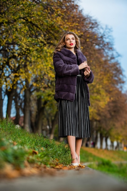 Delicate pleats lady looking trendy walk in street comfortable and warm complement your outfit modern winter fur coat elegant woman red lips wear fur coat the best luxury clothing material