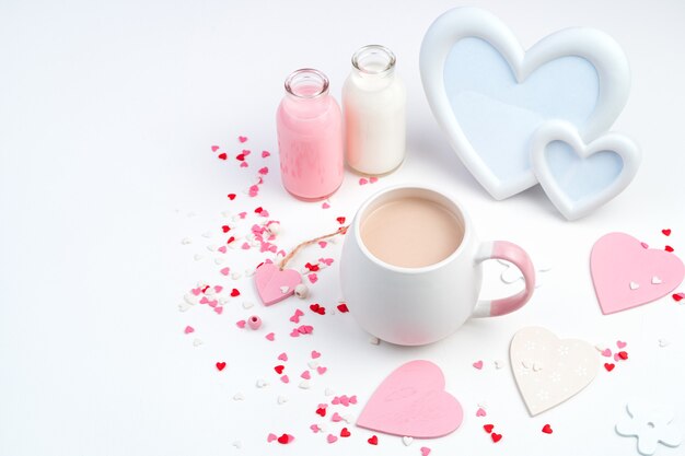 Delicate romantic composition for February 14 with a Cup of coffee, frame, hearts in white and pink