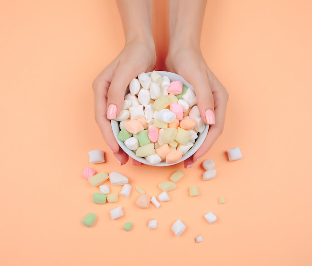 Delicate roze manicure op een trendy koraal tafel.