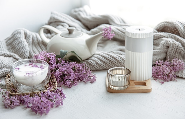 Delicate spring arrangement with flowers in a vase, a glass of milk and home decor details