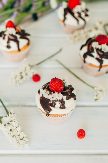 Delicate tasty muffins decorated with raspberries and poured wit