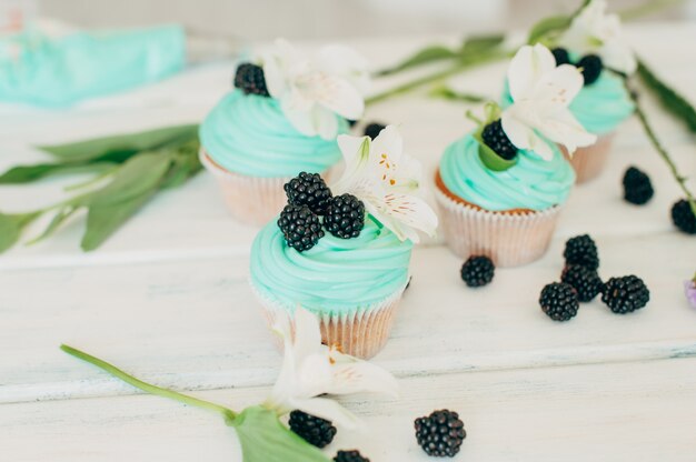 Delicate tasty muffins with mint cream decorated with fresh blac