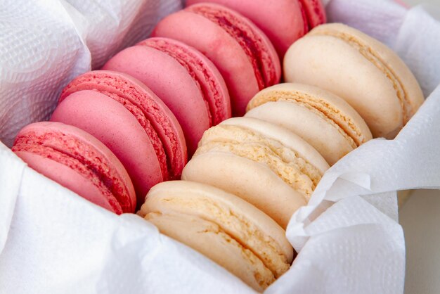 Delicate vanilla and strawberry french macaroons closeup in a box