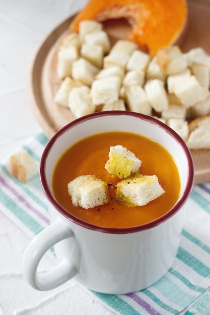 Delicate vegetable cream soup with pumpkin and croutons and slices of pumpkin.
