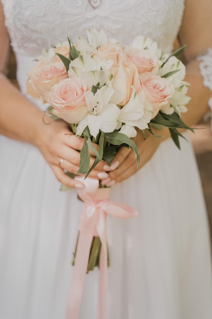 Delicate wedding bouquet in the hands of the bride