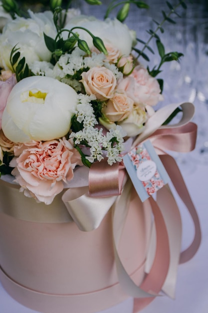 delicate wedding bouquet of peonies of the bride stand on the table, close-up.