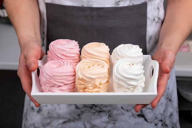 Delicate zelfgemaakte marshmallow in vrouwelijke handen. Koken. Banketbakkerij.