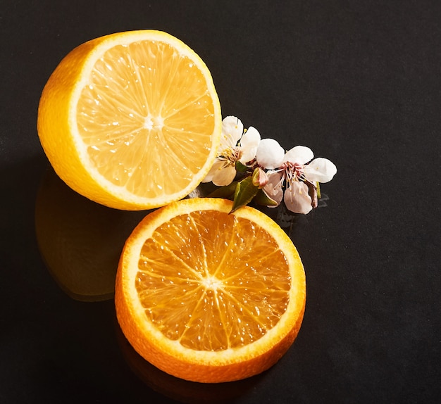 Вкусный и сочный апельсин и лимон, изолированные на черном.